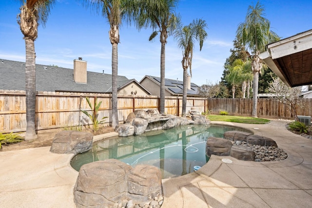 view of pool with a fenced backyard and a garden pond