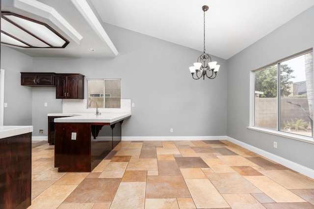 kitchen with a kitchen bar, dark brown cabinetry, a peninsula, and baseboards