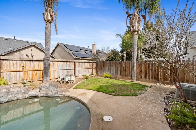 view of pool with a patio area, a fenced backyard, and central AC unit