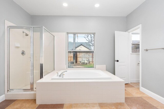 full bathroom featuring a wealth of natural light, a shower stall, and a bath