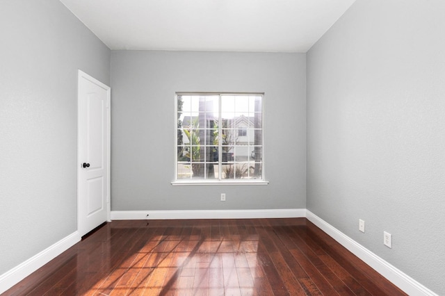 unfurnished room featuring baseboards and hardwood / wood-style flooring