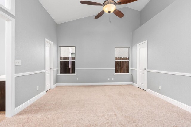 spare room featuring carpet floors, ceiling fan, high vaulted ceiling, and baseboards