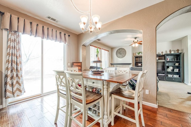 4466 W Artemisa Dr, Fresno, CA 93722 - dining area with arched walkways, a textured wall, ceiling fan with notable chandelier, visible vents, and hardwood / wood-style floors