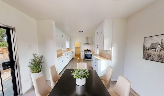 dining area featuring light wood-style flooring and baseboards