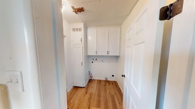 laundry area with washer hookup, cabinet space, light wood-style floors, and baseboards