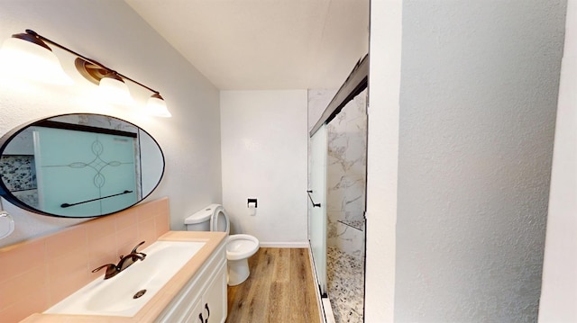 full bathroom featuring tasteful backsplash, a shower stall, toilet, wood finished floors, and vanity