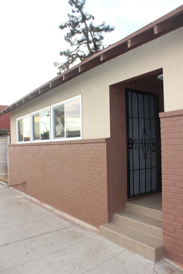 exterior space with brick siding and stucco siding