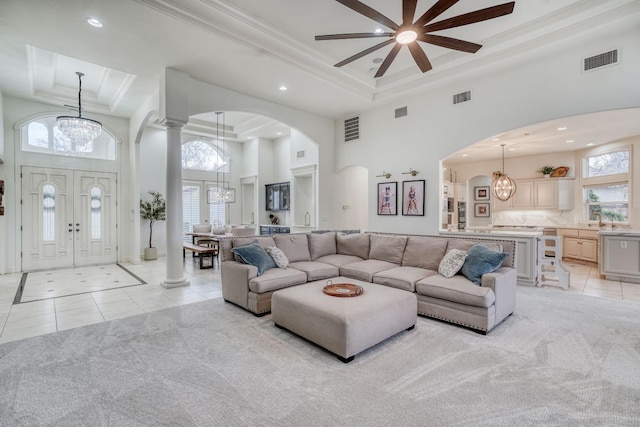 living room with visible vents, a raised ceiling, and a notable chandelier