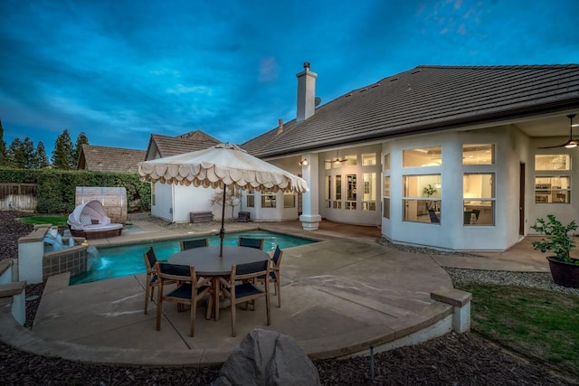 rear view of house featuring a fenced in pool, a tile roof, a patio, stucco siding, and fence