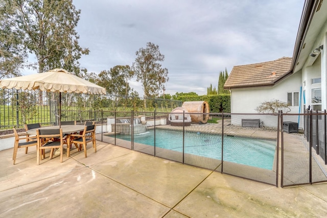 view of swimming pool featuring outdoor dining space, fence, a fenced in pool, and a patio