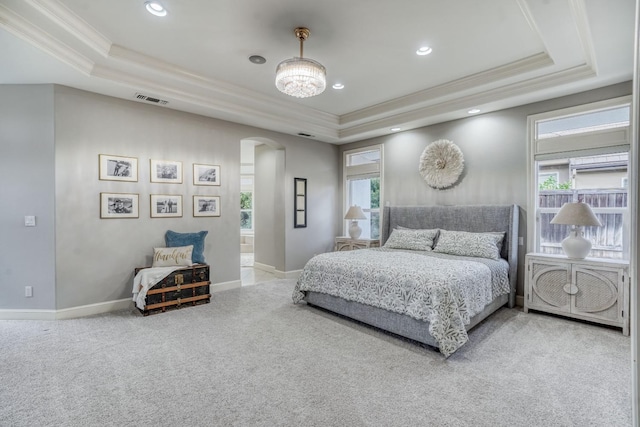 carpeted bedroom with arched walkways, a tray ceiling, multiple windows, and crown molding