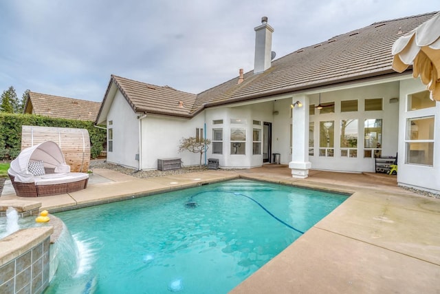 rear view of property with a chimney, a patio area, and a fenced in pool