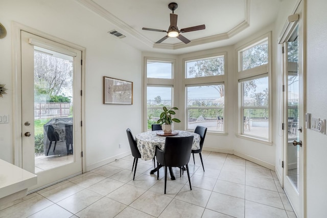 dining space with ornamental molding, a raised ceiling, and a healthy amount of sunlight