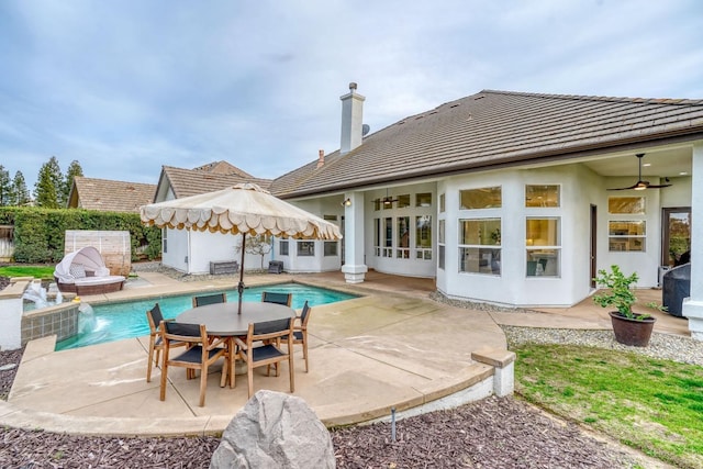 back of property featuring stucco siding, fence, a fenced in pool, and a patio