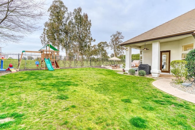 view of yard with a playground, fence, and a patio