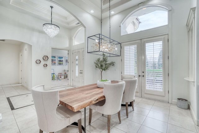 dining room with baseboards, arched walkways, ornamental molding, french doors, and a notable chandelier