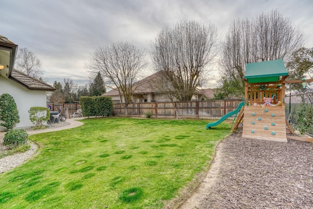 view of yard with a fenced backyard and a playground