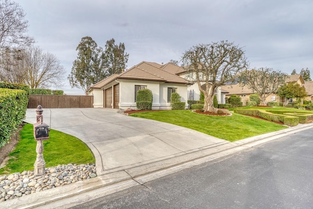 view of front facade featuring stucco siding, an attached garage, a front yard, fence, and driveway