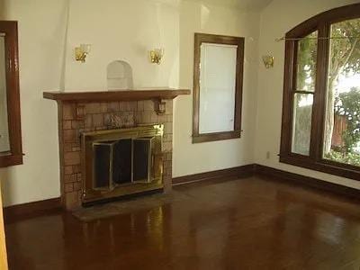 unfurnished living room featuring a fireplace, a wealth of natural light, and baseboards