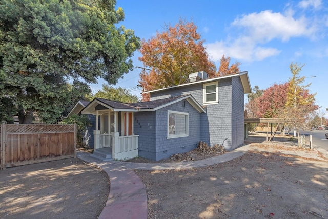 view of front of home with crawl space, a chimney, and fence