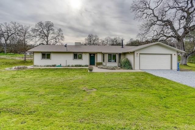 single story home with a garage, a fire pit, driveway, a chimney, and a front yard