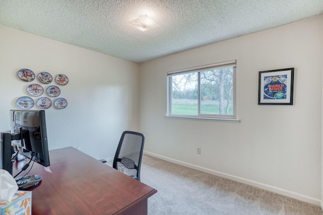 carpeted home office with a textured ceiling and baseboards