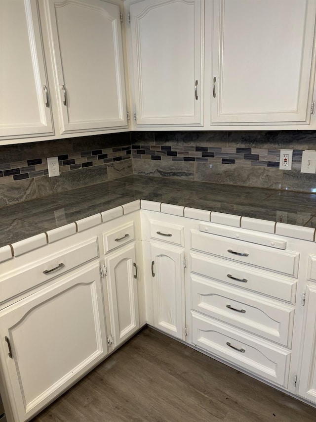 kitchen with tile countertops, white cabinetry, decorative backsplash, and dark wood finished floors