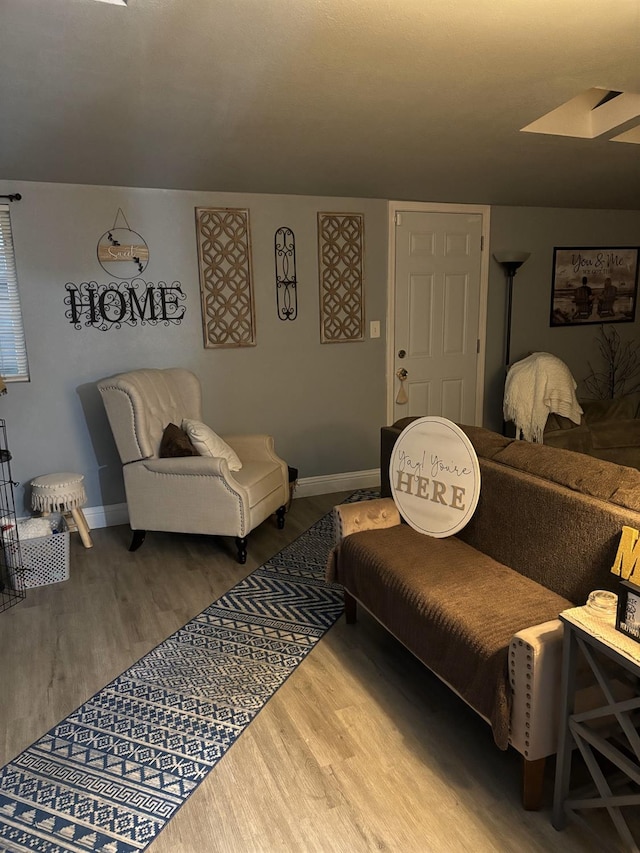 living area featuring baseboards and wood finished floors