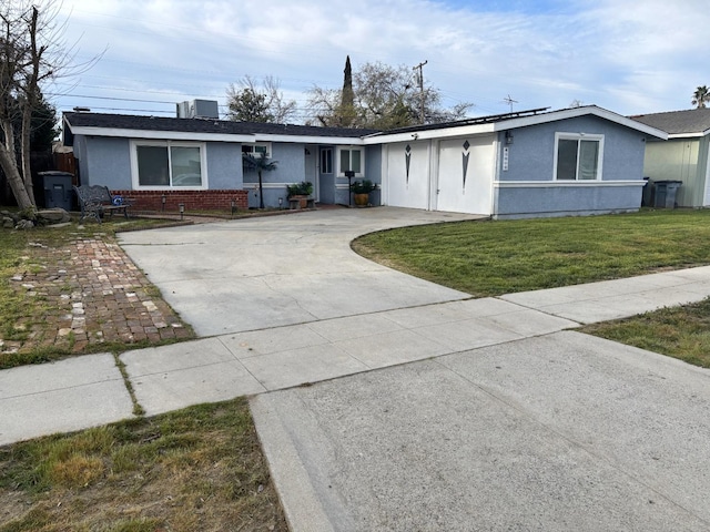 ranch-style home featuring stucco siding, a front lawn, concrete driveway, and brick siding