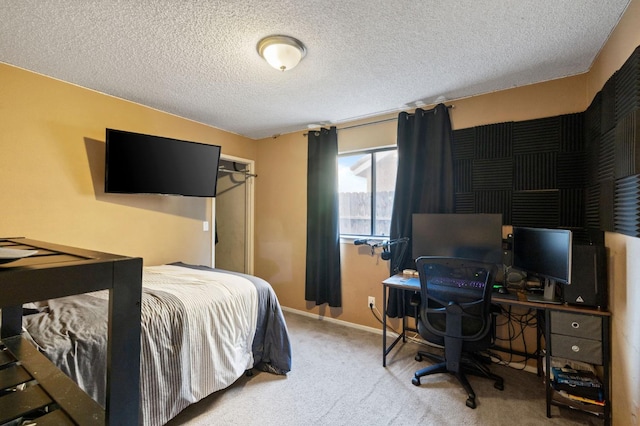 carpeted bedroom featuring baseboards and a textured ceiling