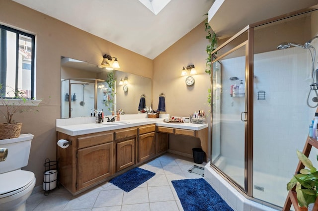 bathroom with toilet, lofted ceiling with skylight, a shower stall, vanity, and tile patterned floors