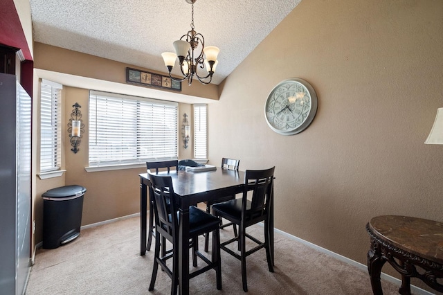 carpeted dining area featuring a notable chandelier, lofted ceiling, a textured wall, a textured ceiling, and baseboards