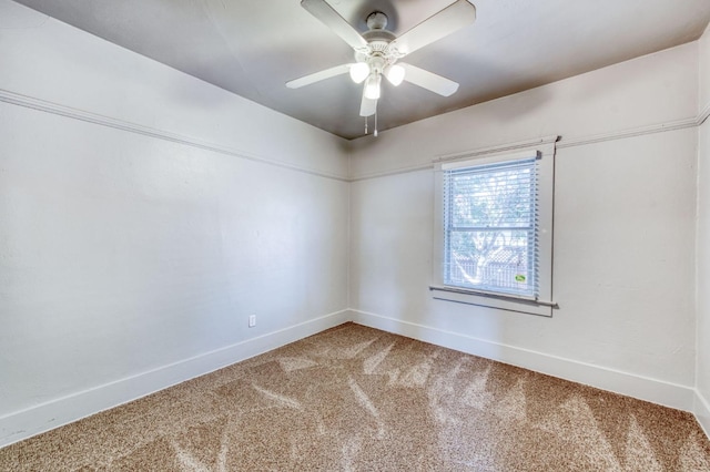 carpeted spare room with ceiling fan and baseboards