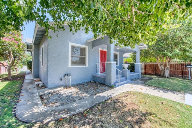 view of front of house with fence and stucco siding