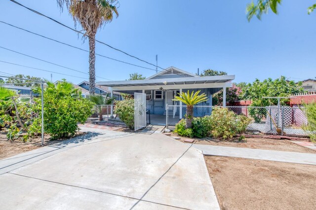 bungalow featuring driveway, a gate, fence, and a porch