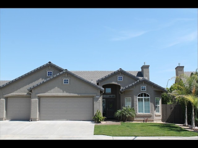 view of front of house featuring stucco siding, an attached garage, a front yard, fence, and driveway