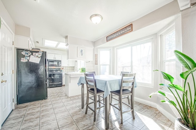 dining room with light tile patterned floors, a wealth of natural light, and baseboards