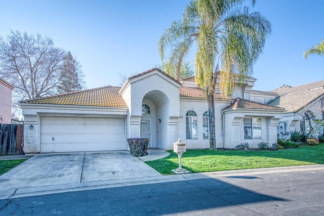 mediterranean / spanish home with a garage, a tiled roof, concrete driveway, stucco siding, and a front yard