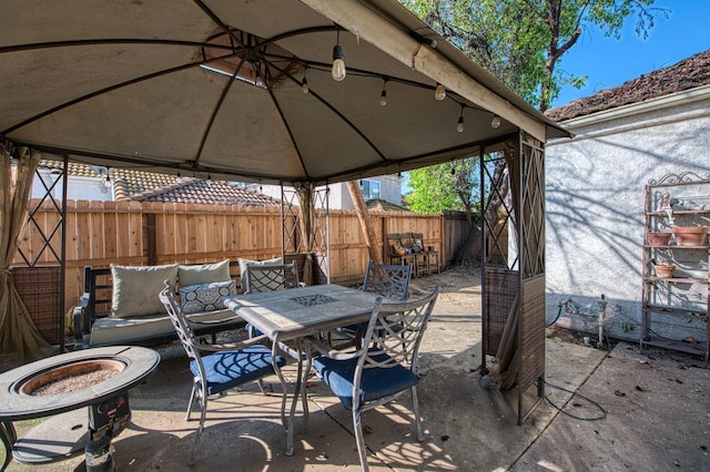 view of patio / terrace featuring outdoor dining area, a fenced backyard, and a gazebo