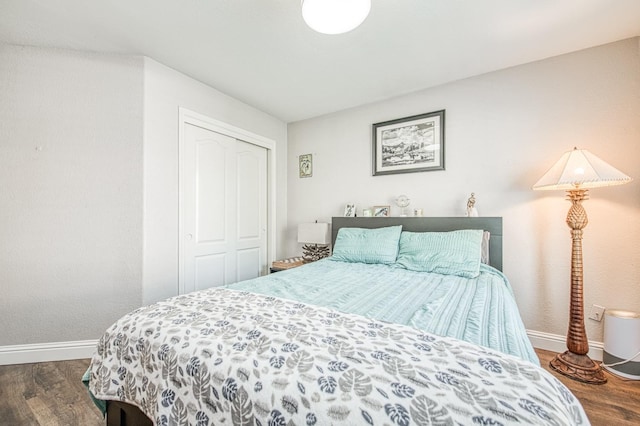 bedroom with a closet, baseboards, and wood finished floors