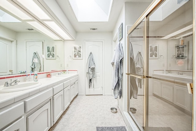 full bath featuring a skylight, a sink, and double vanity