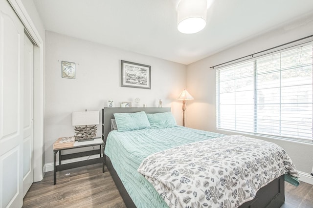 bedroom with a closet, baseboards, and wood finished floors