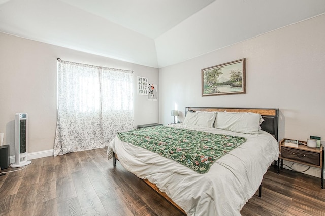 bedroom with lofted ceiling, heating unit, wood finished floors, and baseboards