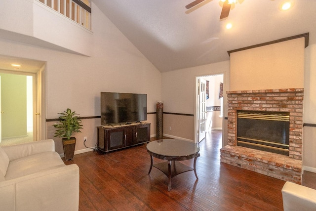 living room featuring baseboards, a ceiling fan, wood finished floors, a brick fireplace, and high vaulted ceiling