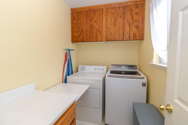 laundry area featuring independent washer and dryer and cabinet space