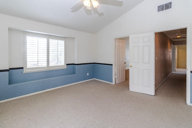 spare room featuring baseboards, visible vents, a ceiling fan, vaulted ceiling, and carpet flooring