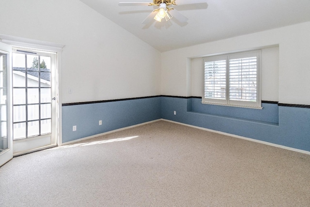 spare room featuring a ceiling fan, baseboards, vaulted ceiling, and carpet flooring