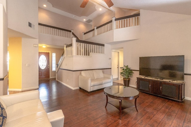 living area featuring hardwood / wood-style flooring, stairs, visible vents, and high vaulted ceiling