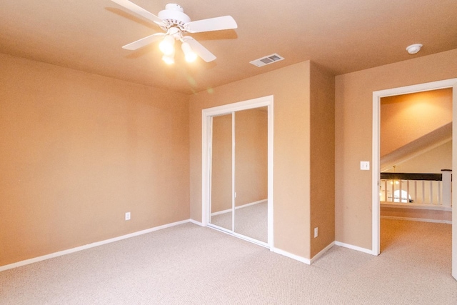 unfurnished bedroom with a ceiling fan, visible vents, light carpet, and baseboards