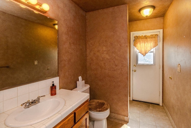 bathroom with vanity, tile patterned flooring, toilet, and baseboards